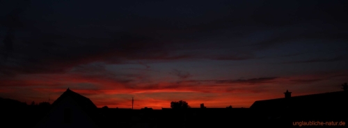 Panorama - Unterbelichteter Sonnenuntergang über Häuserdächern